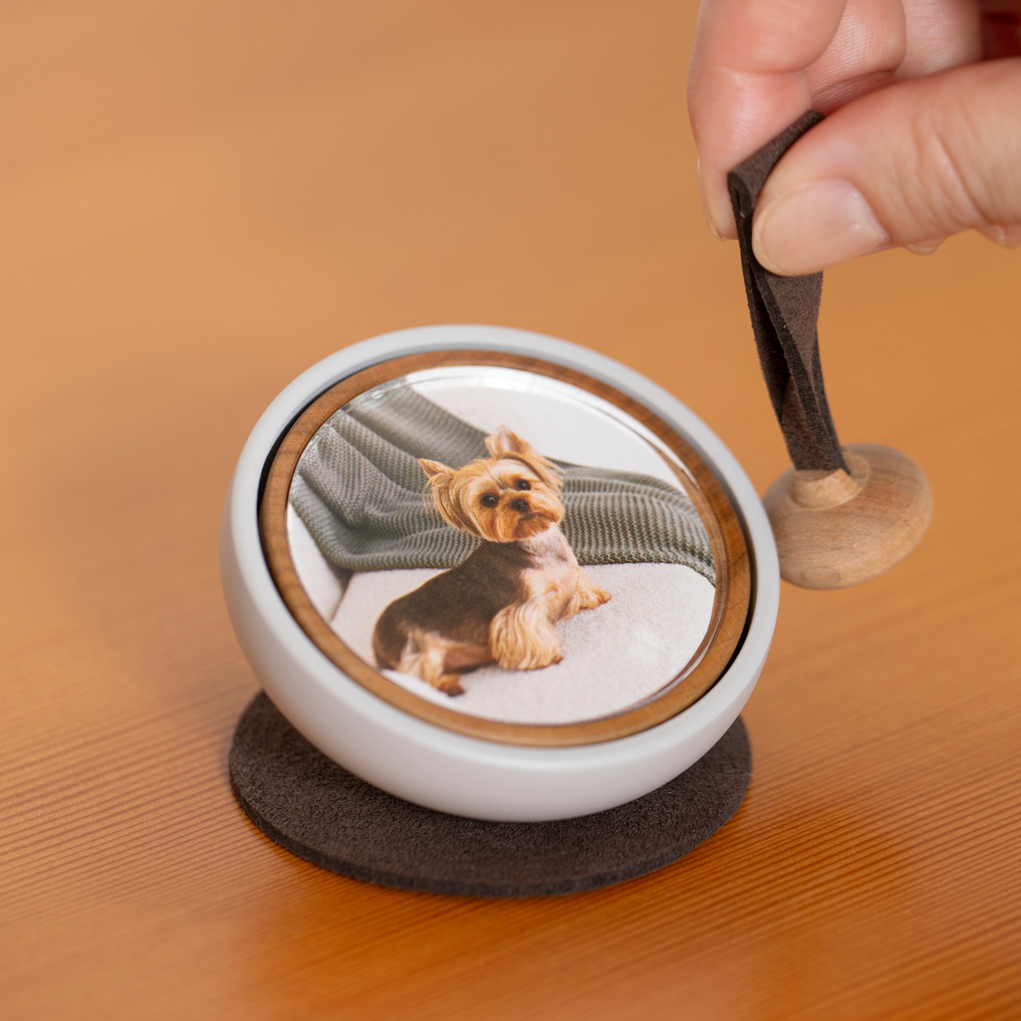 Hand gently ringing the Tailo pet memorial bell with the swaying mallet